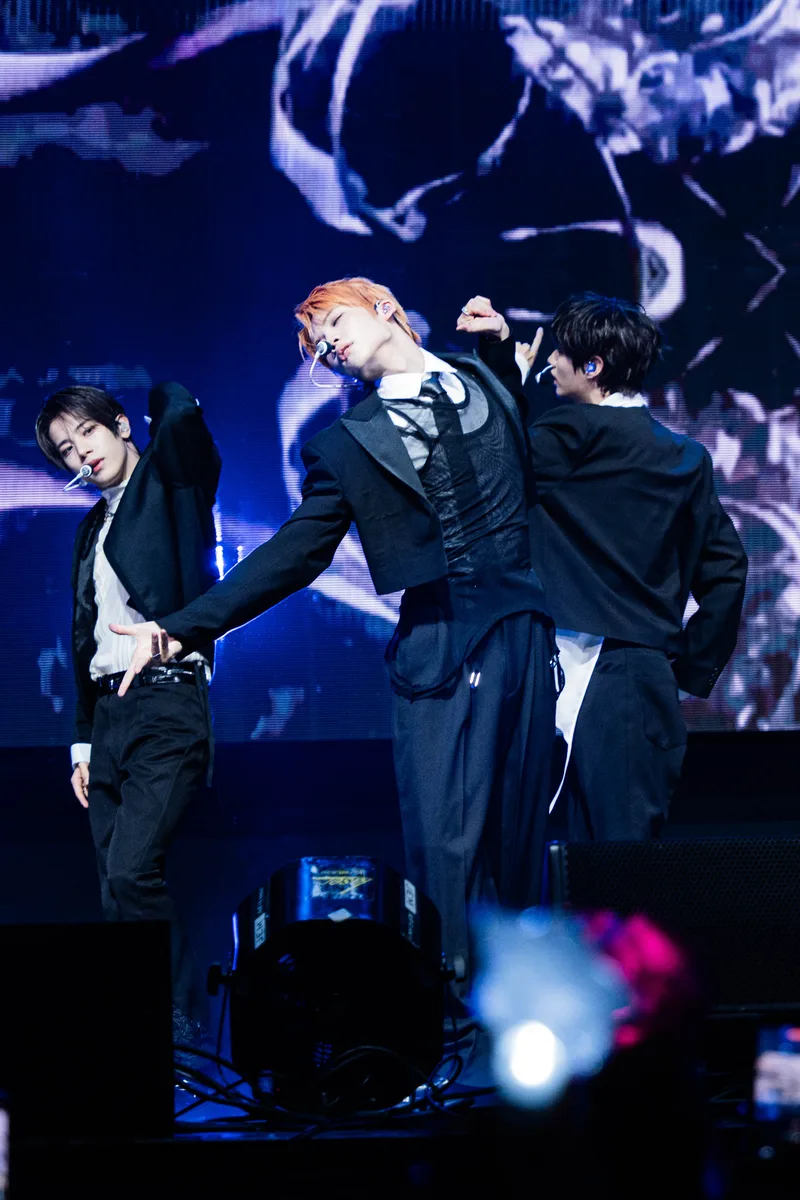 Members of CLOSE YOUR EYES perform K-pop choreography together on stage.